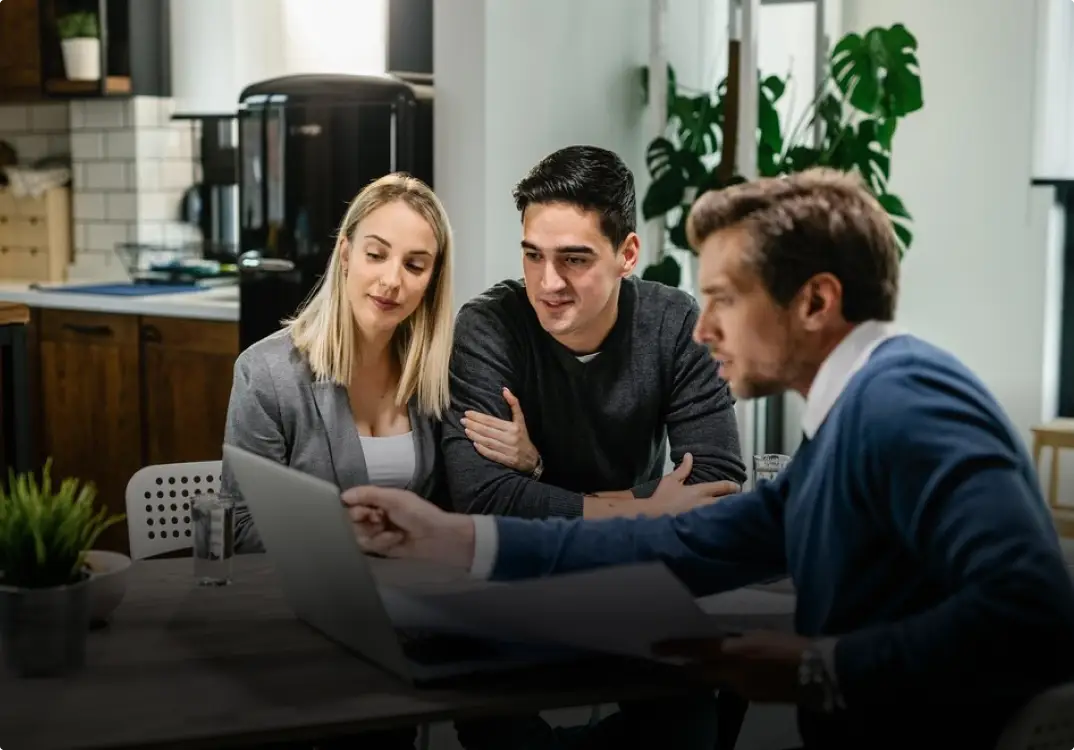 Asesor financiero certificado de Shield Capital explicando una estrategia patrimonial personalizada a una pareja